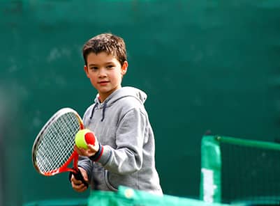 Boy about to serve during tennis match